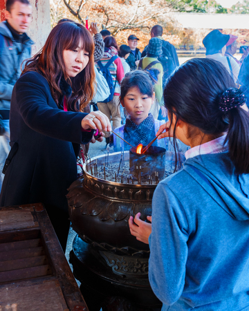 Nara, Japan - November 16 2013   Unidentified people lit up joss sticks to at an incense burner to...