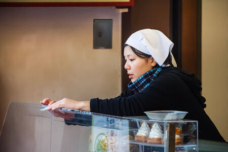 KYOTO, JAPAN - NOVEMBER 20  Japanese Woker in Kyoto, Japan on November 20, 2013  Unidentified Japanese female worker prepare hershop before the openningのeditorial素材