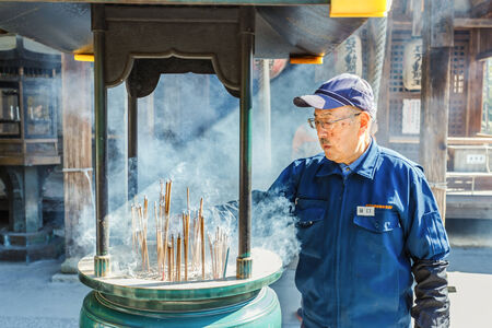 KYOTO, JAPAN - NOVEMBER 20  Incense Burner in Kyoto, Japan on November 20, 2013  Unidentified Japanese officer gets rid of joss sticks from the incense burner at Kinkaku-ji Templeのeditorial素材