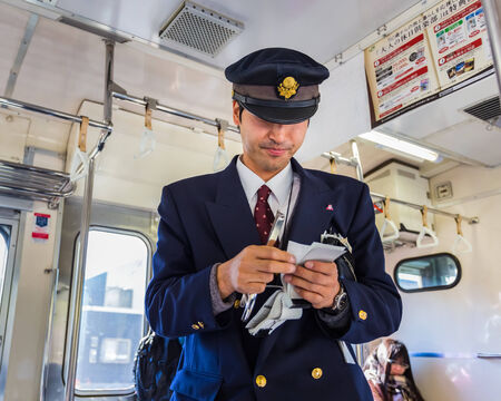 YAMANASHI, JAPAN - NOVEMBER 22  Train Steward in Yamanashi, Japan on November 22, 2013  Train steward of JR train checks for ticket and makes fair adjustment for passengerのeditorial素材