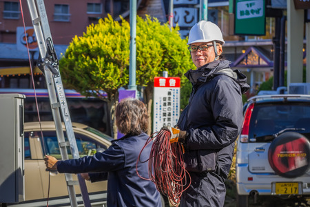 KAWAGUCHIKO, JAPAN - NOVEMBER 22  Fishing People in Kawaguchiko, Japan on November 22, 2013  Unidentified cable man installs cable onto a postのeditorial素材
