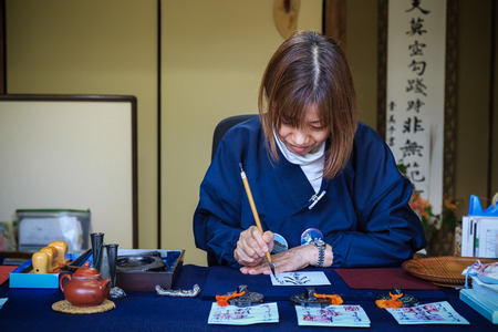 KYOTO, JAPAN - OCTOBER 21: Religious Volunteer in Kyoto, Japan on October 21, 2014. Unidentified Religious Volunteer writes calligraphy on a paper for using as a talisman in Ssisho-in templeのeditorial素材