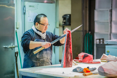 OSAKA, JAPAN - OCTOBER 24: Osaka Central Wholesale Market in Osaka, Japan on October 24, 2014. Unidentified japanese fish seller cut the tuna in sizes before selling to customersのeditorial素材