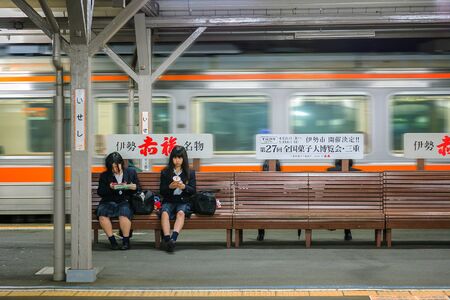 MIE, JAPAN - NOVEMBER 20, 2015: Japanese student on a platform waits for a train home at Ise stationのeditorial素材