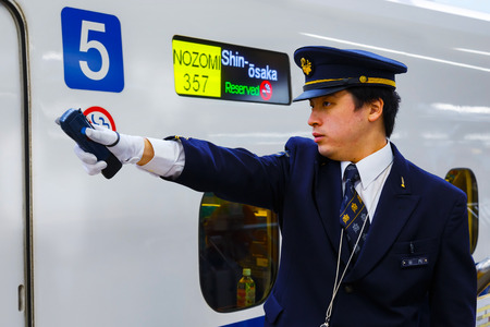 KYOTO, JAPAN - NOVEMBER 23 2015: Unidentified Japanese train conductor on his duty on a Shinkansen platform at Kyoto Stationのeditorial素材