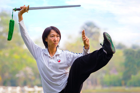 BANGKOK, THAILAND - FEBRUARY 20, 2016: Unidentified group of people practice Chinese sword with Tai Chi Chuan in a parkのeditorial素材