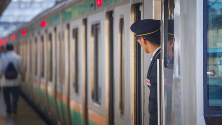 TOKYO, JAPAN - NOVEMBER 29 2015: An unidentified Japanese train conductor is on his duty on a platform at Ikebukuro stationのeditorial素材