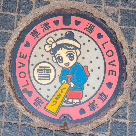 GUNMA, JAPAN - APRIL 27 2018: Yumomi is a traditional way to cool down Kusatsu's hot spring water to bathing temperature without diluting it with cold water, displayed on a manhole coverのeditorial素材