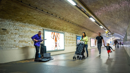 London, UK - May 20 2018: Unidentified street musician performs in a subway tunnel at South Kensington Stationのeditorial素材