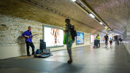 London, UK - May 20 2018: Unidentified street musician performs in a subway tunnel at South Kensington Stationのeditorial素材