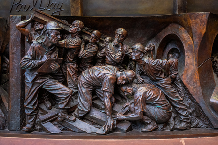 London, UK - May 14 2018: Deatils on the base of The Meeting Place, 9-metre bronze statue revealed in 2007, stands at the south end of the upper level of St Pancras railway station by British artist Paul Day London, UK - May 14 2018: Deatils on the base of The Meeting Place, 9-metre bronze statue revealed in 2007, stands at the south end of the upper level of St Pancras railway station by British artist Paul Day