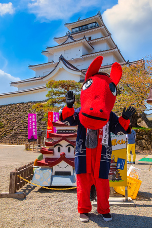Aizuwakamatsu , Japan - April 21 2018: Unidentified Japanese dresses a "Akabeko" a legendary cow from the Aizu region mascot suit at Aizu-Wakamatsu Castleのeditorial素材