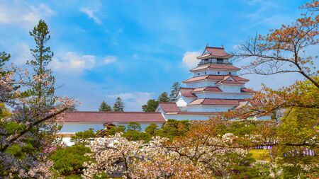 Aizuwakamatsu Castle and cherry blossom in Fukushima, Japan Aizuwakamatsu , Japan - April 21 2018: Aizu-Wakamatsu Castle and cherry blossom built by Ashina Naomori in 1384, Tenshu, the largest tower was reconstructed in 1965 in concreteのeditorial素材