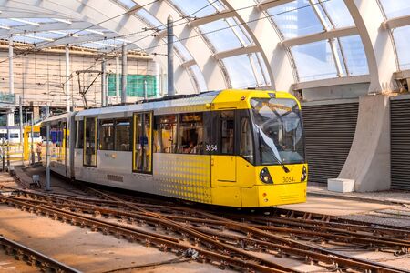 Manchester, UK - May 18 2018: Light rail Metrolink tram in the city center of Manchester, UK. The system has 77 stops along 78.1 km and runs through seven of the ten boroughsのeditorial素材