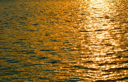 Sunset, golden light on the water surfaceの写真素材