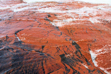Water flowing over beautiful red jasper surfaceの写真素材