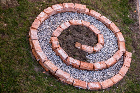 spiral herb garden with soil and pebbles