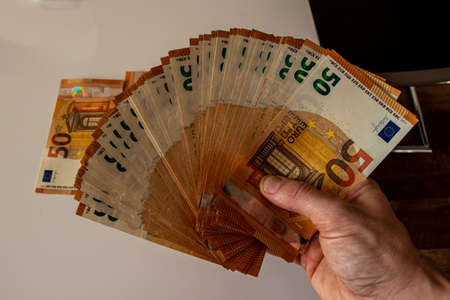 A pack of fifty euro note in hand, close up