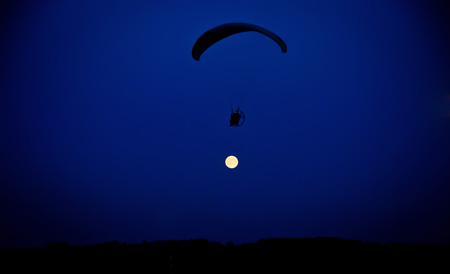 Skydiver flying against the sky with the moonの写真素材
