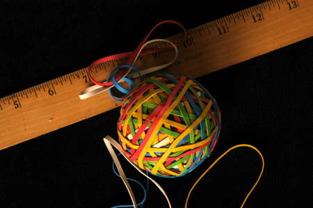 rubber band ball and ruler on blackの写真素材