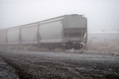 railroad cars on track in foggy morning light