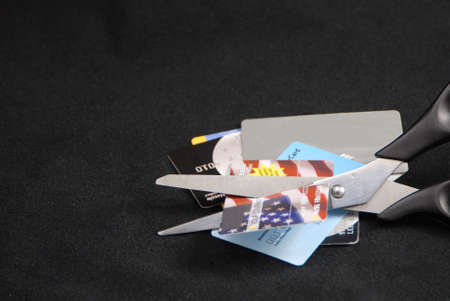 cutting credit cards with scissors on blackの写真素材