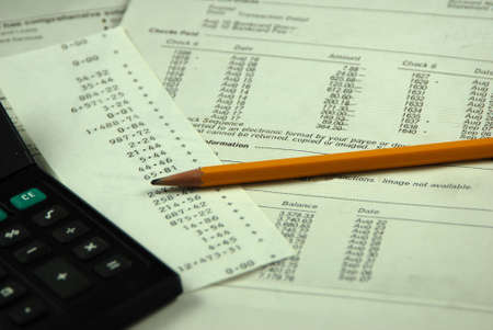 balancing business bank statement with pencil and calculatorの写真素材