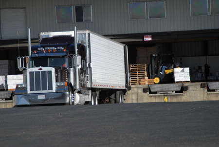 semi truck at fruit warehouse being loaded