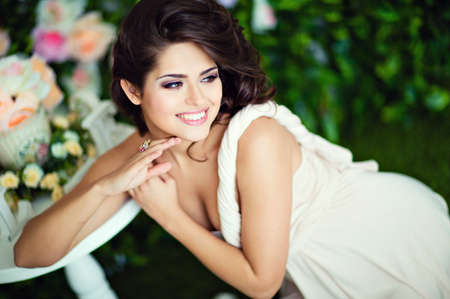 Very beautiful girl brunette in a beige dress laughs and looks awayの写真素材