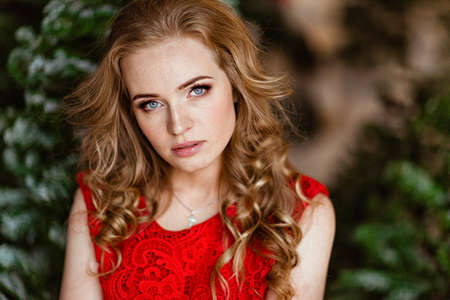 Portrait of a red haired girl in red dressの写真素材