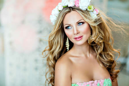 Very beautiful and sensual blonde girl with a wreath of delicate spring flowers, close upの写真素材