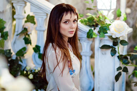 Portrait of a sensual beautiful brunette with brown eyes in the interiors of the house, in beige. In the background is a ladder and a flashlightの写真素材