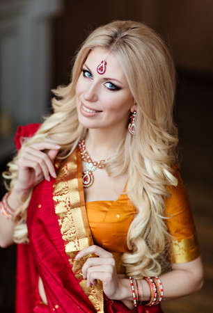 beautiful blonde girl in Indian red saree around the Christmas treeの写真素材