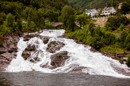 beautiful large waterfall in Norway in cloudy weatherの写真素材