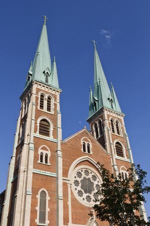 Two elegant church spires reaching toward a blue skyの写真素材
