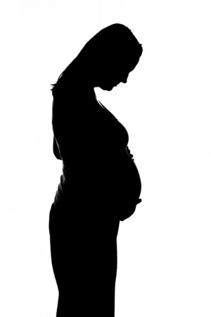 Silhouette of a woman in late pregnancy against a white backgroundの写真素材