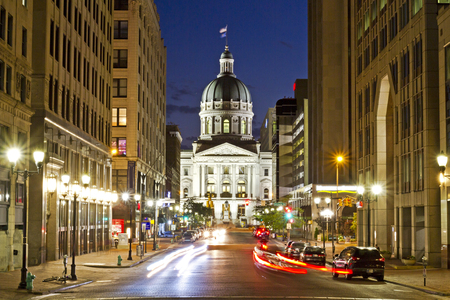 A dramatic view of the Indiana capitol building at night in Indianapolis, with busy streets and a long exposureの写真素材