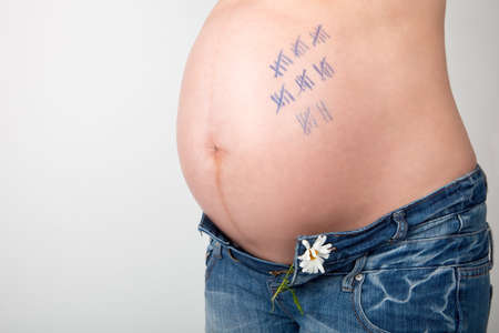 Stomach of a pregnant woman with numbers until the birthの写真素材