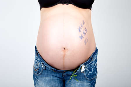 Stomach of a pregnant woman with numbers until the birthの写真素材
