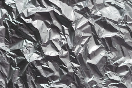 Crumpled silver foil texture for background. Gray paper background.の素材