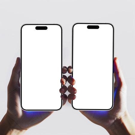 Two hands holding a smartphone with a blank screen on a white backgroundの素材