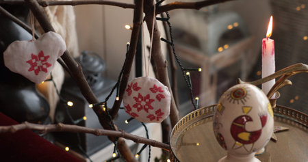 Handcrafted decorations adorn a natural branch, showcasing heart and round shapes with beautiful...