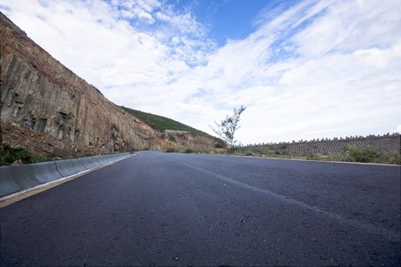 Asphalt road blue sky with clouds and mountains の写真素材