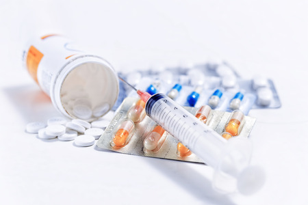 Syringe with glass vials and medications pills drugの写真素材
