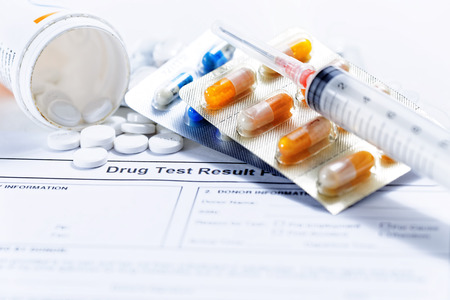 Syringe with glass vials and medications pills drug test reportの写真素材
