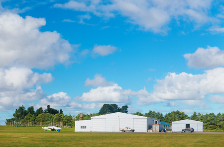 Metallic warehouse with blue sky green grassの写真素材