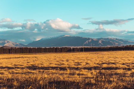 Road travel in the green mountains of New Zealand view from car window. Scenic peaks and ridges. Beautiful background of amazing nature.の写真素材