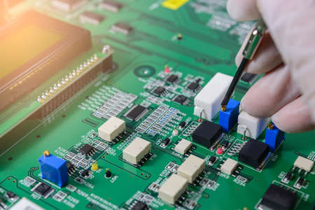 Close-up Of A Male Technician Repairing electronic board.の写真素材