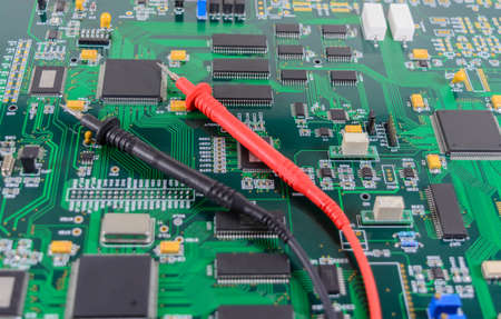 Multimeter test probes on printed circuit board
