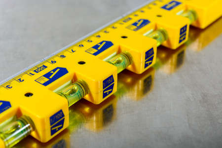 yellow construction level on stainless steel backgroundの写真素材